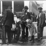 Personas tomando agua durante un dia caluroso en la ciudad