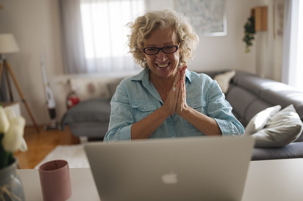 Mujer sonriendo durante una videollamada familiar